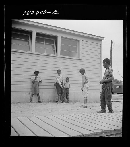 Untitled photo, possibly related to: Arlington, Virginia. FSA (Farm Security Administration) trailer camp project for Negroes. Children playing marbles outside the community building