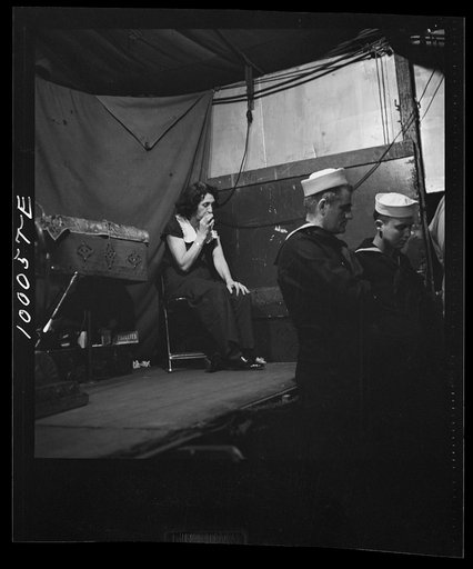 Norfolk, Virginia. Sword swallower in a travelling railroad show resting between acts