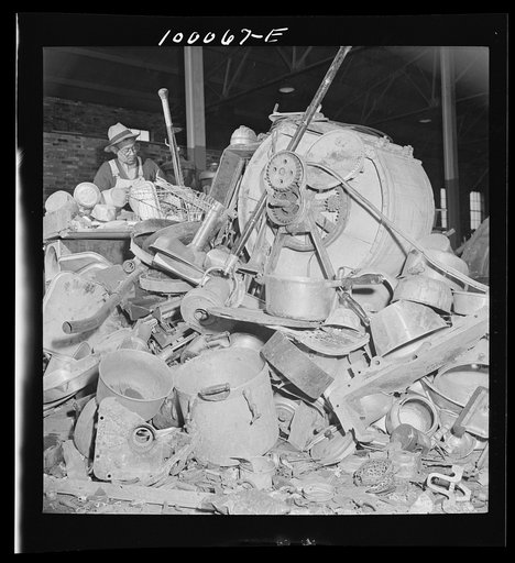 Washington, D.C. Salvage drive, Victory Program. Miscellaneous metal scrap in warehouse of District wholesale junk company. Man in background is "cleaning" metal objects
