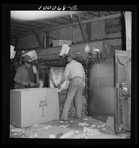 Untitled photo, possibly related to: Washington, D.C. Salvage drive, Victory Program. Scrap paper, after being packed in hydraulic press, is baled with wire in District retail junk company