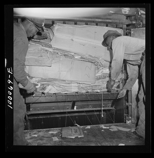 Washington, D.C. Salvage drive, Victory Program. Scrap paper, after being packed in hydraulic press, is baled with wire in District retail junk company