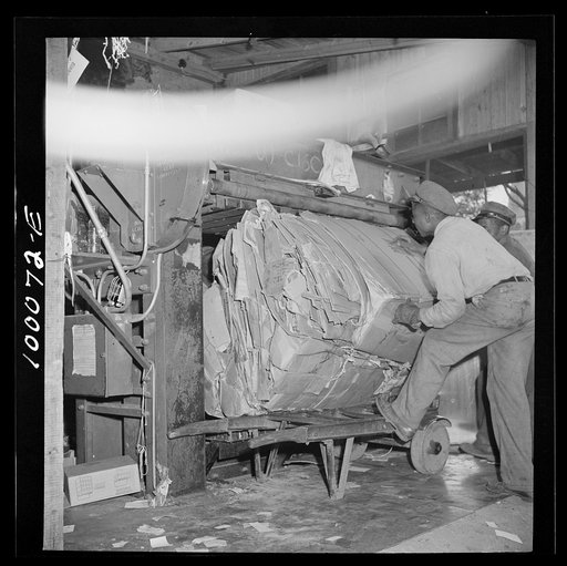 Washington, D.C. Salvage drive, Victory Program. Bales of pressed scrap paper being unloaded from hydraulic press in District retail paper company