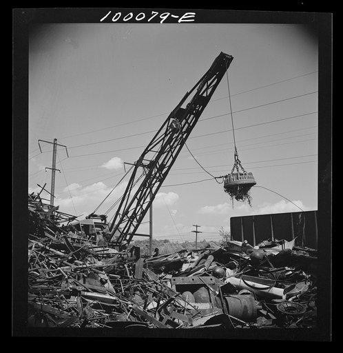 Untitled photo, possibly related to: Washington, D.C. Scrap salvage campaign, Victory Program. Electro-magnet loads metal scrap onto freight car in wholesale junkyard