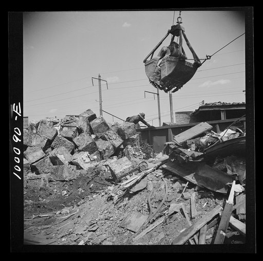 Washington, D.C. Scrap salvage campaign, Victory Program. Crane loads blocks of scrap metal onto a freight car in yard of wholesale junk company