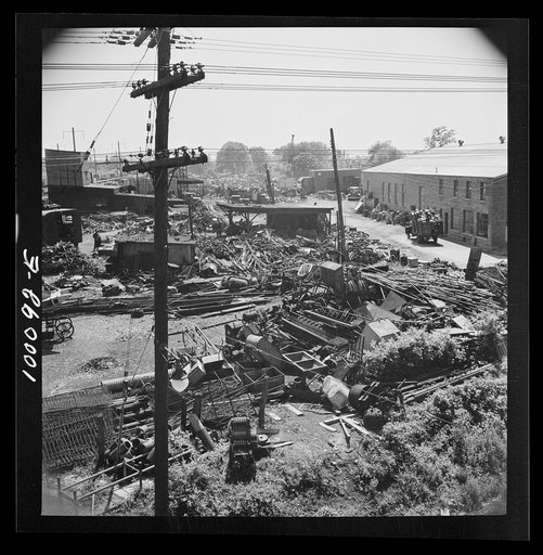 Untitled photo, possibly related to: Washington, D.C. Scrap salvage campaign, Victory Program. Wholesale junkyard beside siding in rear background. Truck in right foreground is being weighed on platform scale before unloading