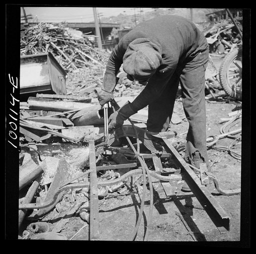 Untitled photo, possibly related to: Washington, D.C. Scrap salvage campaign, Victory Program. Using acetylene torch to break up metal scrap before shipment from a wholesale junk yard