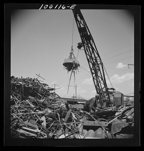 Untitled photo, possibly related to: Washington, D.C. Scrap salvage campaign, Victory Program. Electro-magnet loads metal scrap onto freight car in wholesale junkyard