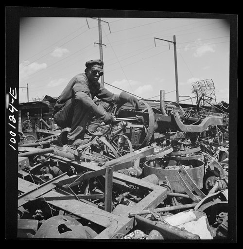 Untitled photo, possibly related to: Washington, D.C. Scrap salvage campaign, Victory Program. Using acetylene torch to break up metal scrap before shipment from a wholesale junk yard