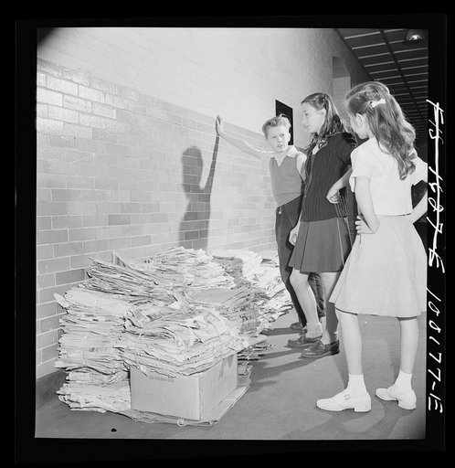 Washington, D.C. Scrap salvage campaign, Victory Program. After bringing their scrap paper to school, each class stacks their contributions outside the classroom door. Here the student council is shown judging one pile. Classes compete for the greatest amount on a chart kept in the hall