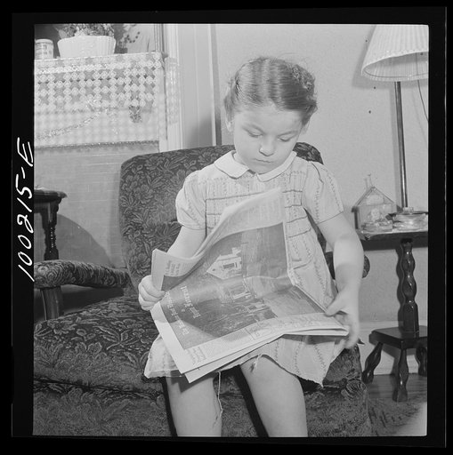 Washington, D.C. Scrap salvage campaign, Victory Program. This little girl folds the Sunday paper to take to school for contribution in the scrap collecting campaign