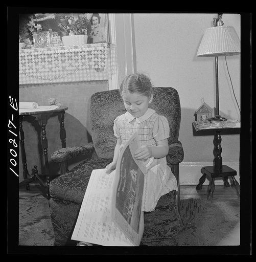 Untitled photo, possibly related to: Washington, D.C. Scrap salvage campaign, Victory Program. This little girl folds the Sunday paper to take to school for contribution in the scrap collecting campaign