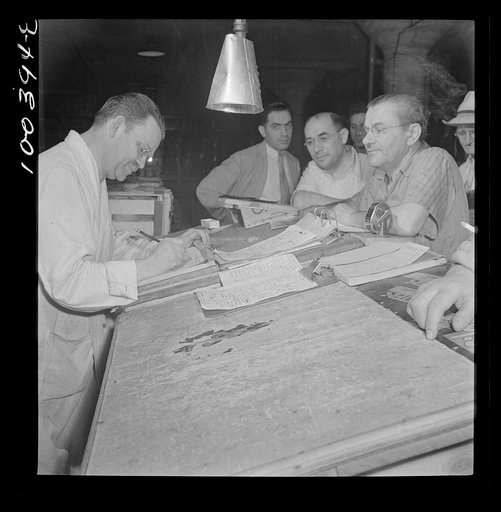 Washington, D.C. District grocery store warehouse on 4th Street S.W. Order clerk settling accounts with merchants who come to make their purchases about 5 a.m.