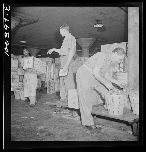 Washington, D.C. District grocery store warehouse on 4th Street S.W. Man on the platform calls out orders, which the men of the produce department are loading onto small trucks. This goes on from about 2 to 5 a.m.
