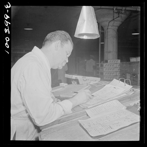 Washington, D.C. District grocery store warehouse on 4th Street S.W. Order clerk making out bills for the store owners who come to the market about 5 a.m. Others telephone their orders