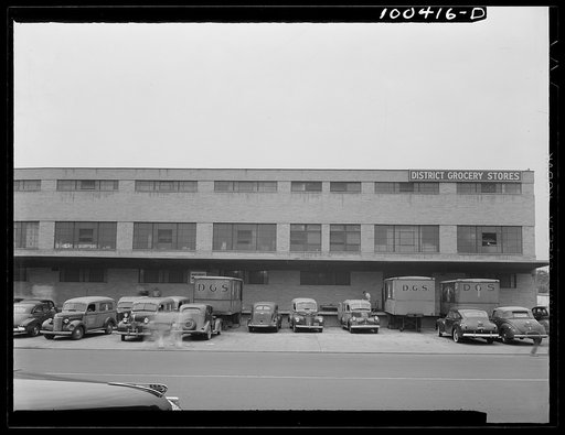 Washington, D.C. District grocery store warehouse on 4th Street S.W. Trucks large and small, lined up in front of the warehouse at dawn, to be loaded for delivery