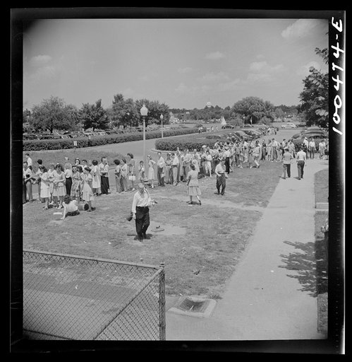Washington, D.C. Line of prospective swimmers, awaiting their turn at the municipal swimming pool on Sunday. The Capitol is in the background