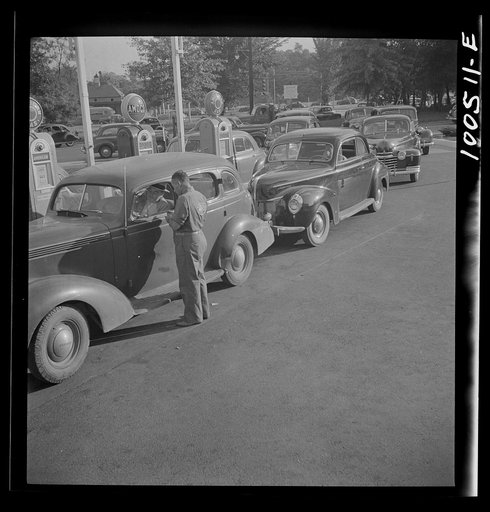 Washington, D.C. On morning of July 21st, the last day before stricter gas rationing went into effect, cars were parked in front of gas stations long before they opened, waiting to fill their tanks on the quota of their old ration cards. Cars were parked and left without their drivers who returned a