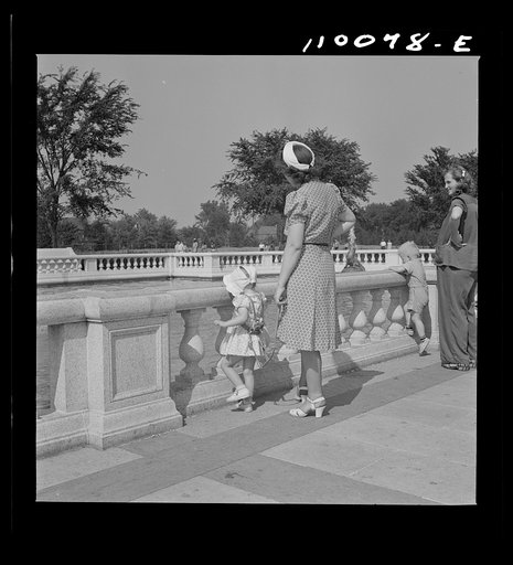 Untitled photo, possibly related to: Detroit, Michigan. Woman adjusting a harness strap to prevent child from getting lost in zoological park