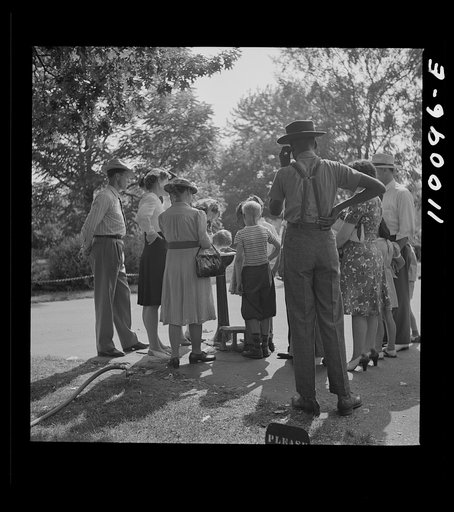 Detroit, Michigan. Group waiting to drink water out of a public fountain in the zoological park