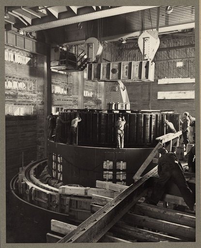 Norris Dam, Tenn. 1935-40? Workmen in the dam powerhouse installing a generator