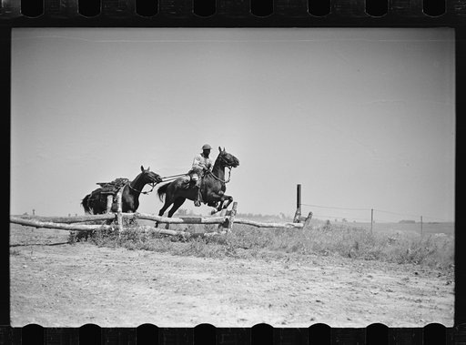 Fort Riley, Kansas. Soldiers of a cavalry machine gun platoon going over an obstacle during a field problem