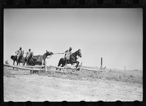 Fort Riley, Kansas. Soldiers of a cavalry machine gun platoon going over an obstacle during a field problem