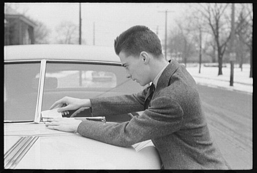 Wilmington, Delaware. Tower Hill School, noted country day school for pupils from three to eighteen years of age. One of the day school pupils who drives to attend school, reading a ticket he received for parking in a "no parking" area