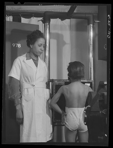 Miss Marion Rhodes, a graduate nurse from Meharry Medical College, Nashville, Tennessee, assisting the x-raying of one of the children on the project. X-ray clinic at the hospital, Ida B. Wells Housing Project, Chicago, Illinois