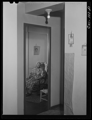 Untitled photo, possibly related to: Portrait of Mrs. Ella Patterson, the oldest resident at the Ida B. Wells Housing Project, Chicago, Illinois. She is 102 years old. On the wall hangs a picture of her daughter