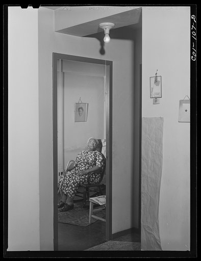 Untitled photo, possibly related to: Portrait of Mrs. Ella Patterson, the oldest resident at the Ida B. Wells Housing Project, Chicago, Illinois. She is 102 years old. On the wall hangs a picture of her daughter