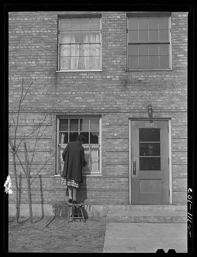 Mrs. Josephine Edwards washing the windows at her apartment. Ida B. Wells Housing Project, Chicago, Illinois