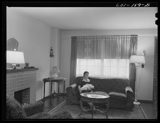 Mrs. Merchant and baby in the living room of their apartment. They have a two-floor apartment--five rooms including kitchen and bath. Mr. Merchant works at the Carnegie Steel Company's South Chicago plant. They have three children: Frank, eight; Rosemary, eight; and baby, four months old. Ida B. Wel