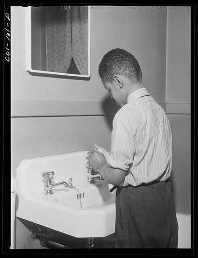 Mr. Frank Merchant washes his hands before going down to dinner. They have a two-floor apartment-- five rooms including kitchen and bath. Mr. Merchant works at the Carnegie Steel Company's South Chicago plant. They have three children: Frank, eight; Rosemary, eight; and baby, four months old. Ida B.