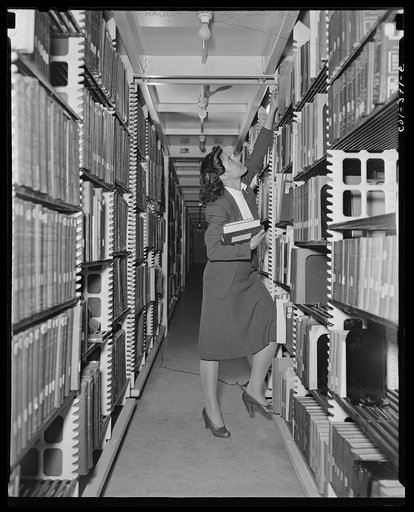 Untitled photo, possibly related to: Washington, D.C. Jewal Mazique [i.e. Jewel] working in the stacks of the Library of Congress