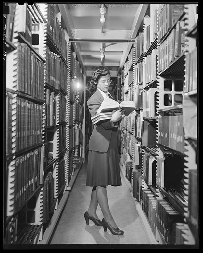 Untitled photo, possibly related to: Washington, D.C. Jewal Mazique [i.e. Jewel] working in the stacks of the Library of Congress