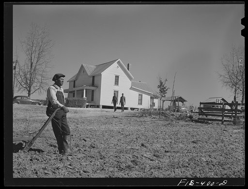 Untitled photo, possibly related to: Zebulon, North Carolina. Feggen Jones resting on a plow in the field near his house