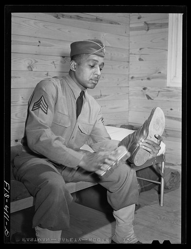 Untitled photo, possibly related to: Fort Bragg, North Carolina. Sergeant Williams polishing his shoes in the barracks