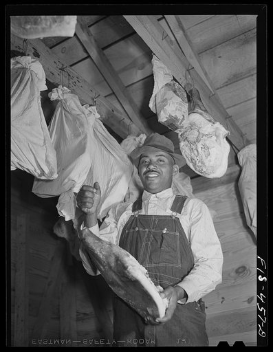 Zebulon, North Carolina. Feggen Jones hanging meat in the smokehouse