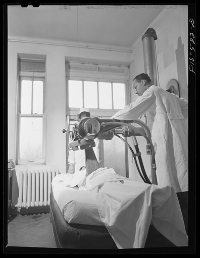Chicago, Illinois. Provident Hospital. Dr. B.W. Anthony adjusting machine to administer x-ray treatment to a patient