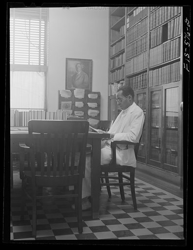 Untitled photo, possibly related to: Chicago, Illinois. Provident Hospital. Dr. E.V. Williams, an intern, in the library
