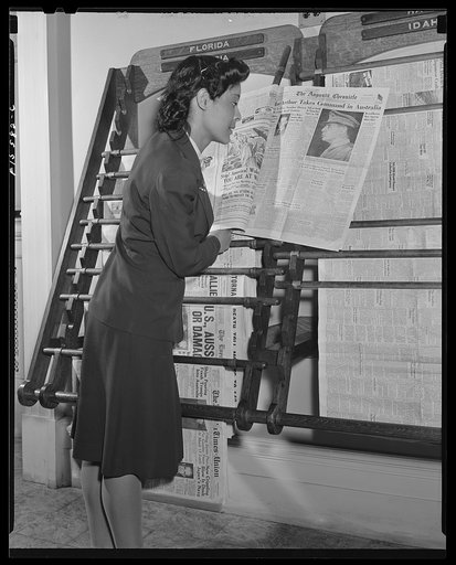 Untitled photo, possibly related to: Washington, D.C. Jewal Mazique [i.e. Jewel], worker at the Library of Congress, reading a hometown paper