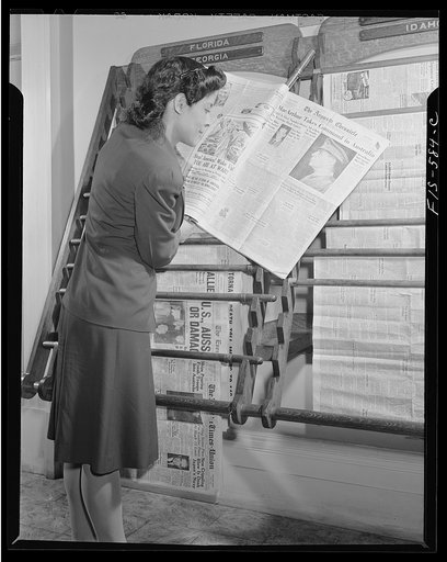 Washington, D.C. Jewal Mazique [i.e. Jewel], worker at the Library of Congress, reading a hometown paper
