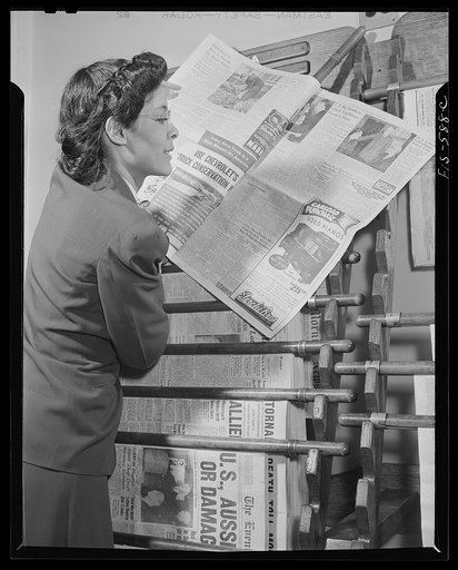 Washington, D.C. Jewal Mazique [i.e. Jewel], worker at the Library of Congress, reading a hometown paper