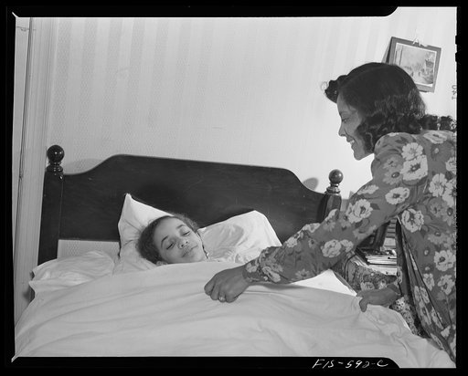 Washington, D.C. Jewal Mazique [i.e. Jewel], worker at the Library of Congress, tucking in one of her nieces for the night