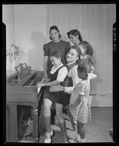 Washington, D.C. Jewal Mazique [i.e. Jewel], worker at the Library of Congress, with her family around the piano