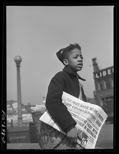 Chicago, Illinois. Newsboy selling the Chicago Defender, a leading Negro newspaper