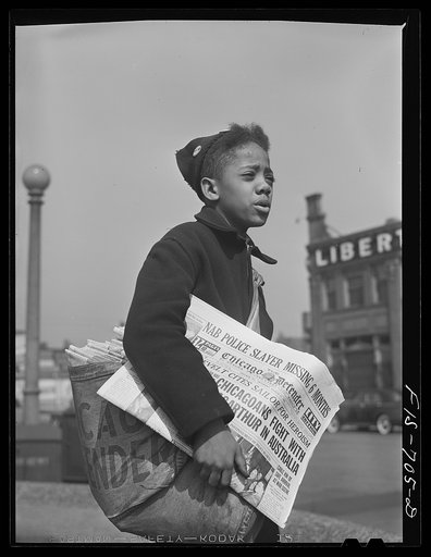 Chicago, Illinois. Newsboy selling the Chicago Defender, a leading Negro newspaper