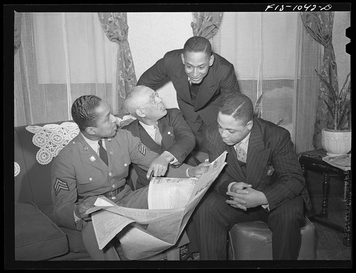 Baltimore, Maryland. Sargenat Franklin Williams, home on leave from Army duty, with his father, brother, and brother-in-law discussing the news after dinner