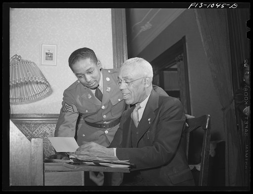 Untitled photo, possibly related to: Baltimore, Maryland. Sargeant Franklin Williams, home on leave from Army duty, discussing insurance problems with his father