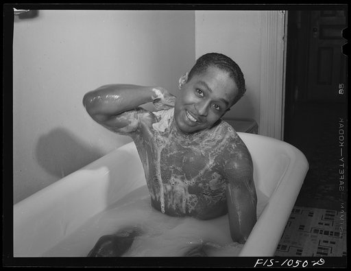 Baltimore, Maryland. Sargeant Franklin Williams, home on leave from Army duty, taking a bath